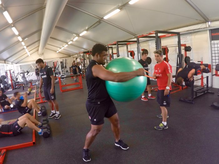 Benjamin Del Moral accompagnant Napolioni Nalaga au cours d'un exercice de core training.